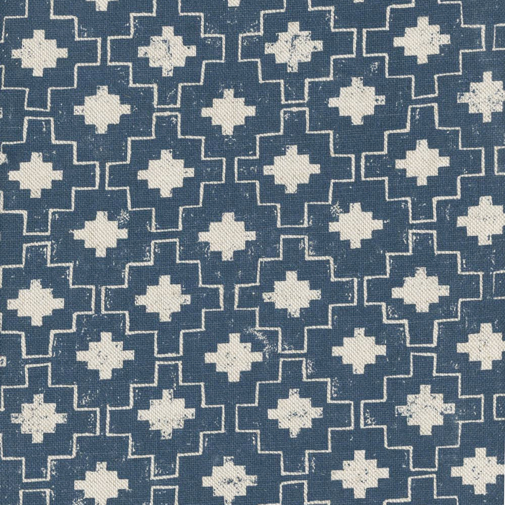 Detail of fabric in a geometric grid print in white on a navy field.