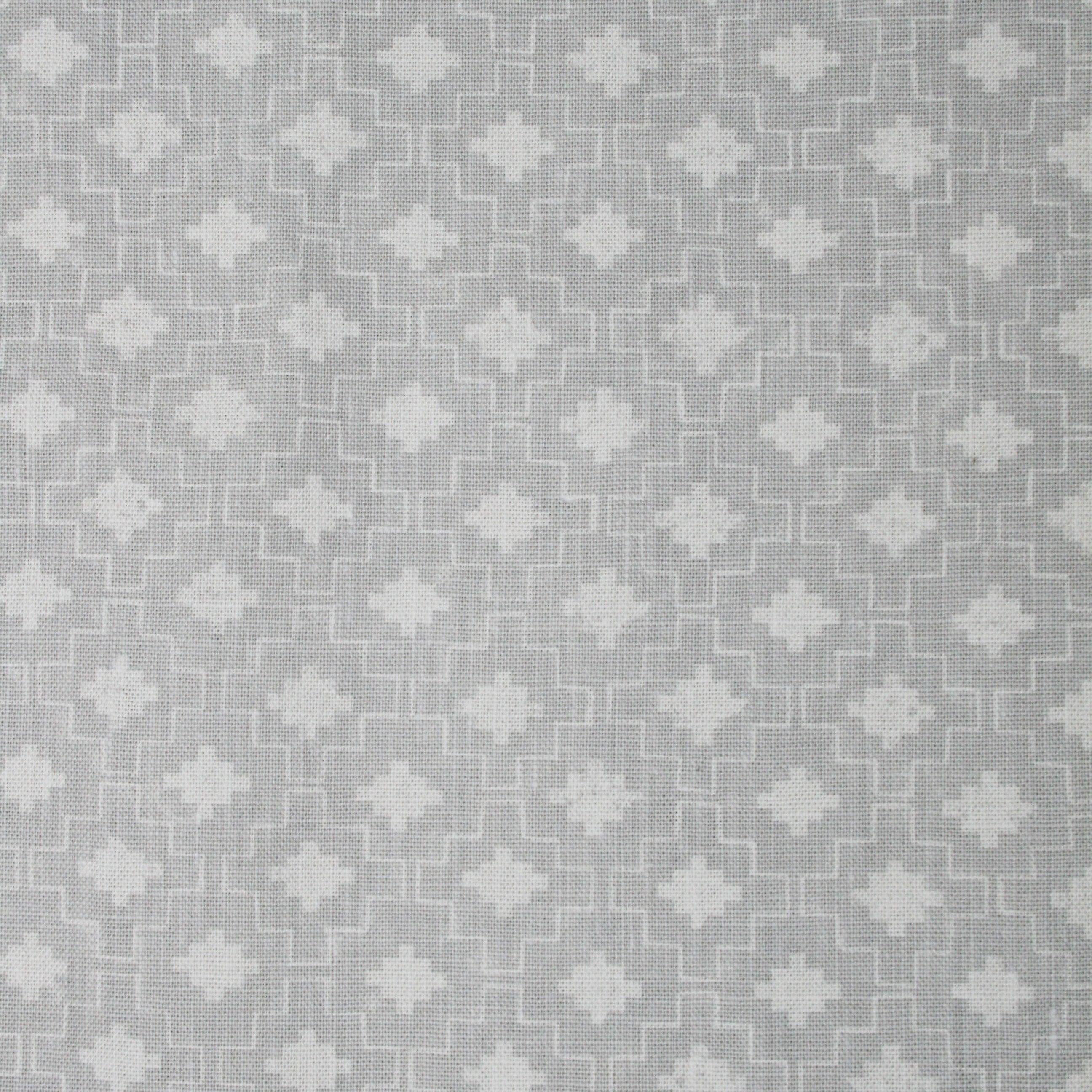 Detail of fabric in a geometric grid print in white on a gray field.