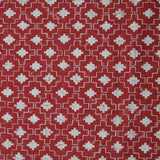 Detail of fabric in a geometric grid print in white on a red field.