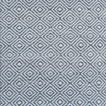 Patterned rug with a geometric diamond design in grey and white.