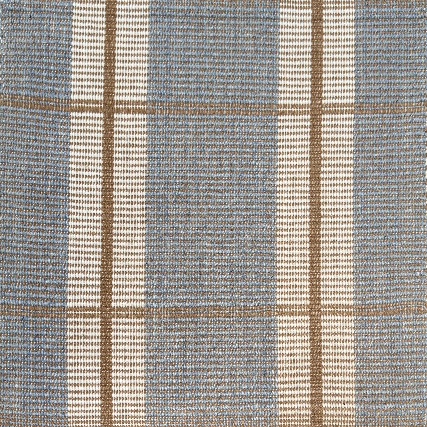 Woven rug with plaid pattern in blue, beige, and white