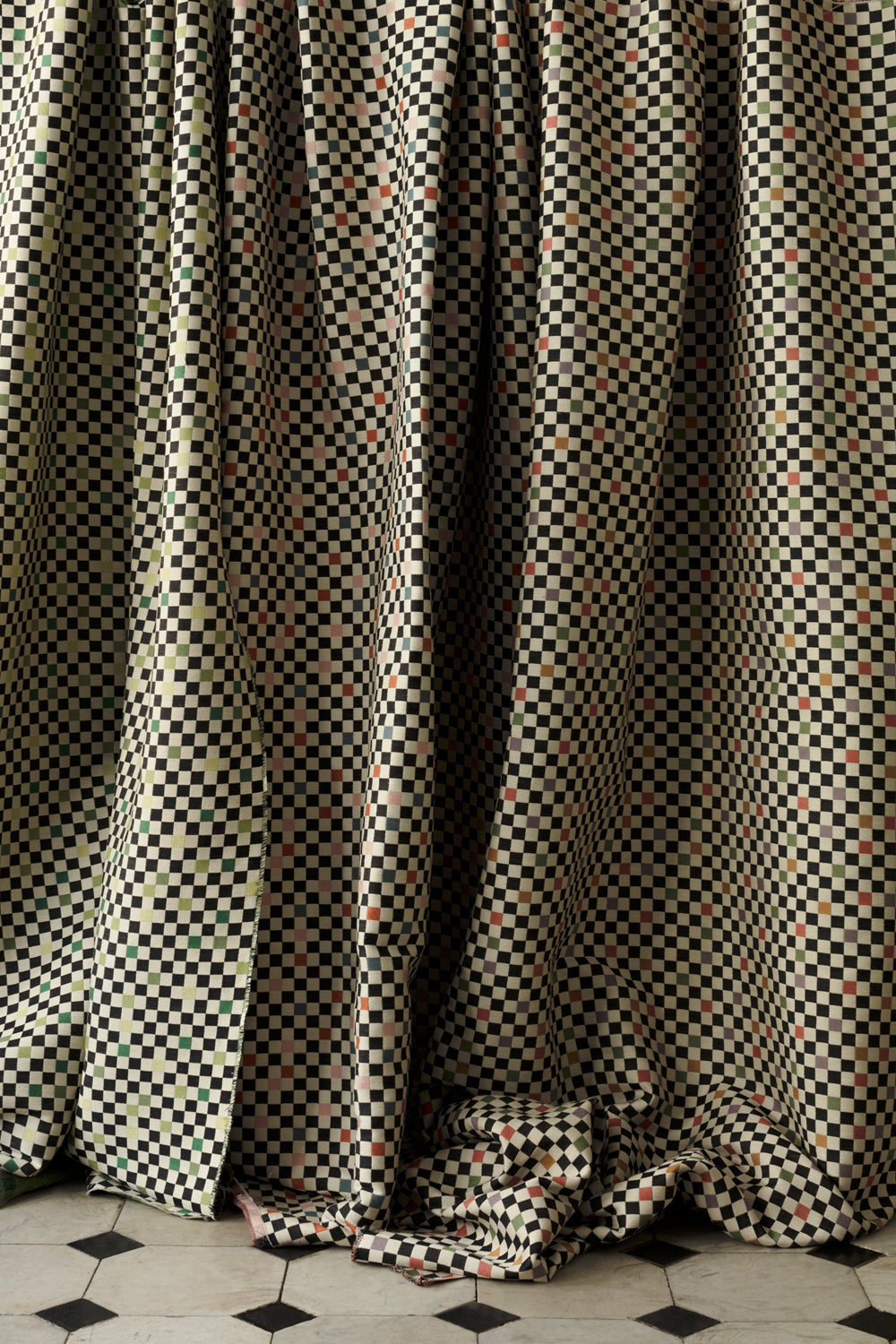 A row of draped jacquard fabrics, all in checked patterns in various colorways.