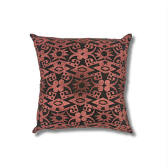 Square throw pillow in a repeating abstract block print pattern in mottled pink on a black field.