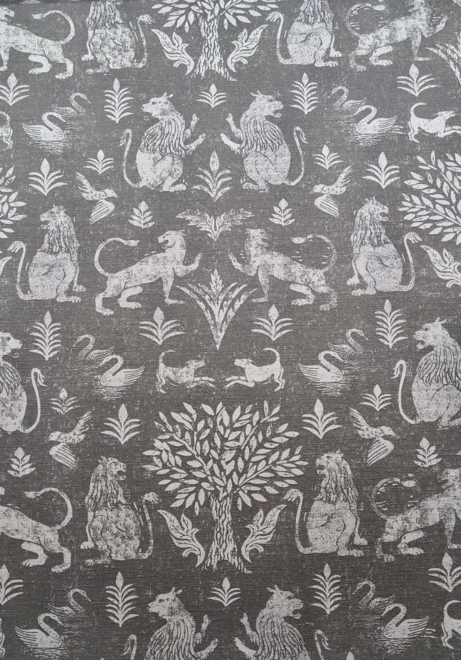 Detail of fabric in a lion and plant print in white on a mottled gray field.