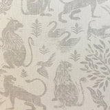 Close-up of fabric in a lion and plant print in gray on a mottled cream field.