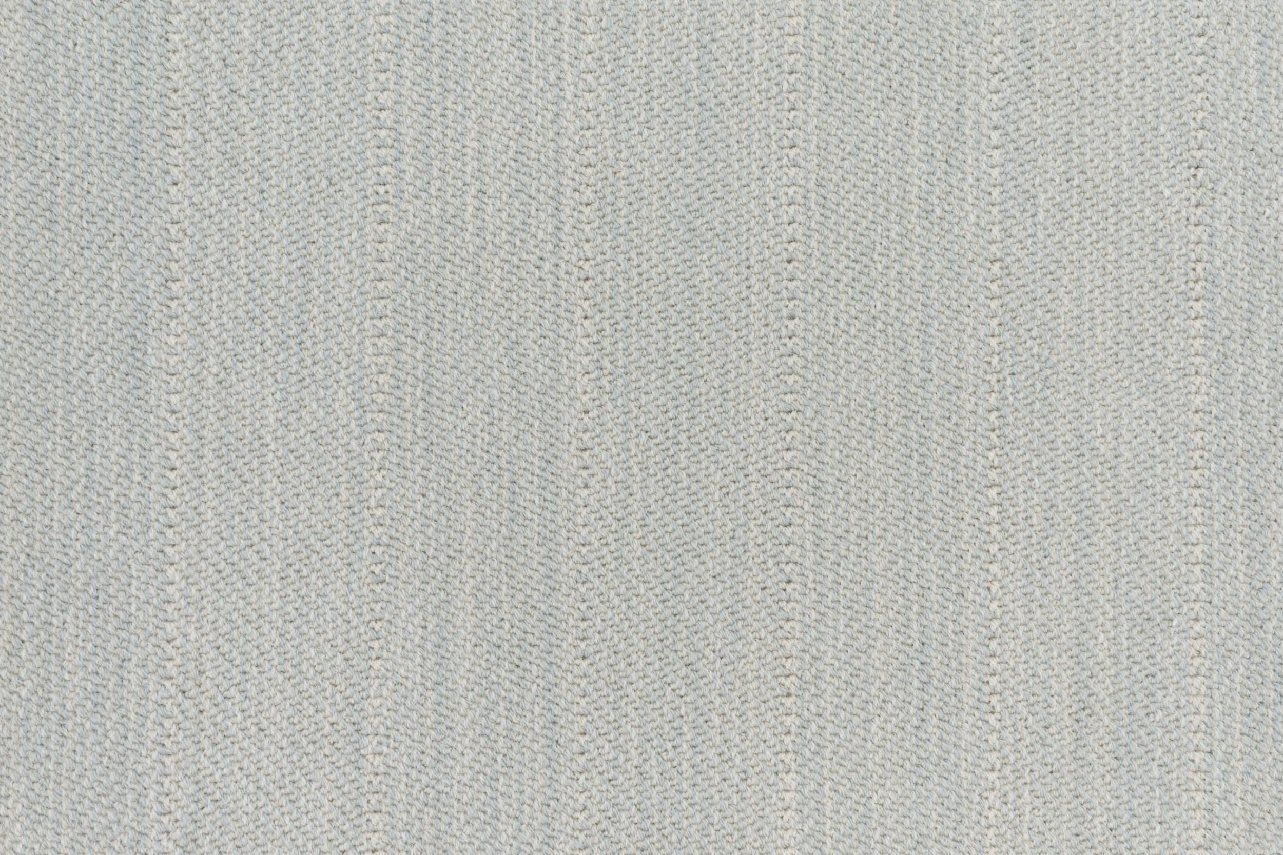 Close up of a broadloom carpet with a herringbone stripe in pale blue.