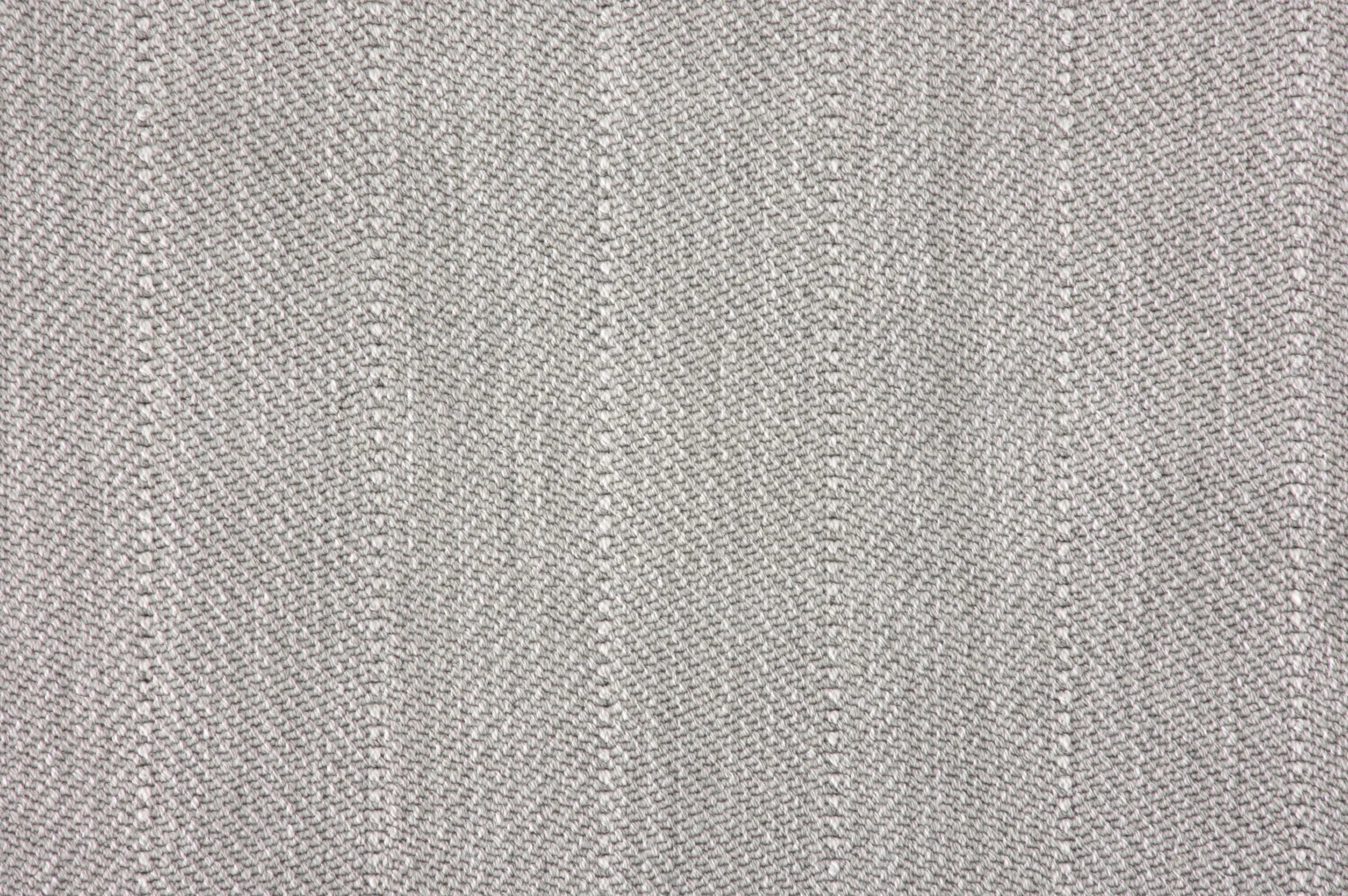 Close up of a broadloom carpet with a herringbone stripe in grey.