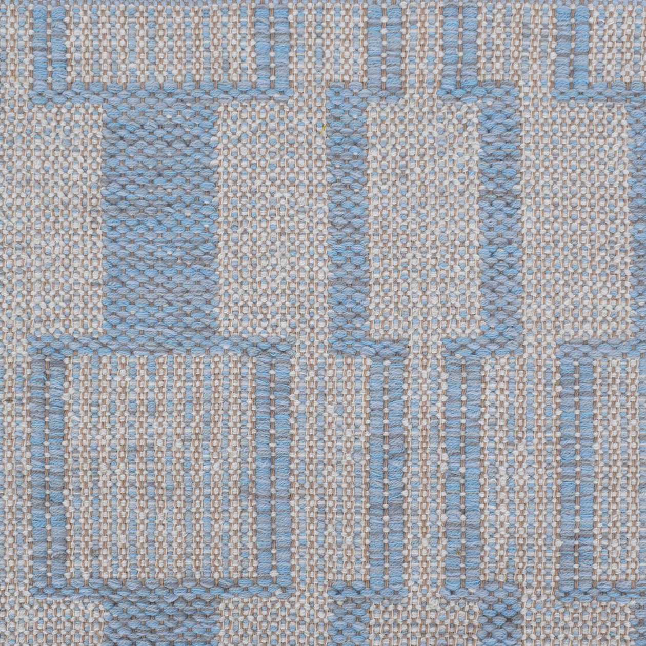 Handwoven rug detail in a dimensional design in blue and beige