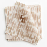 A stack of fabric swatches in a linear check pattern in shades of tan and brown on a white field.