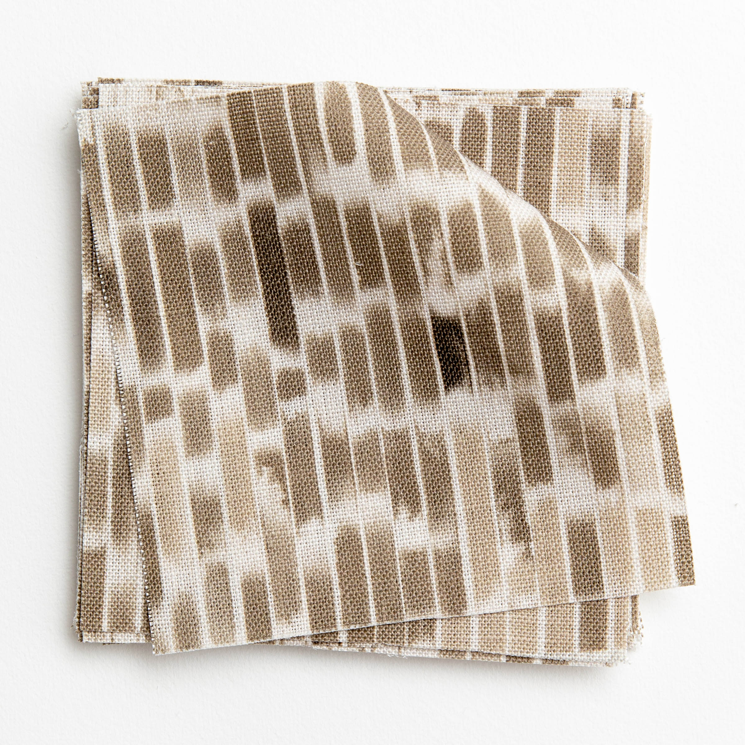 A stack of fabric swatches in a linear check pattern in shades of brown on a white field.