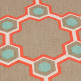 Fabric yardage in a geometric honeycomb pattern in shades of tan, white, blue and coral.