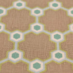 Fabric yardage in a geometric honeycomb pattern in shades of green, blue, cream and brown.