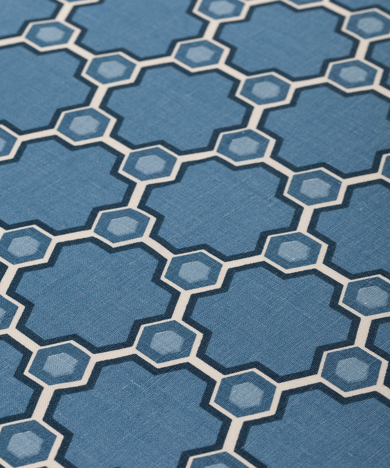 Fabric yardage in a geometric honeycomb pattern in shades of blue, cream and charcoal.