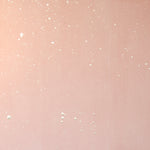 Detail of a wallpaper in a random splattered pattern in metallic cream on a pink field.