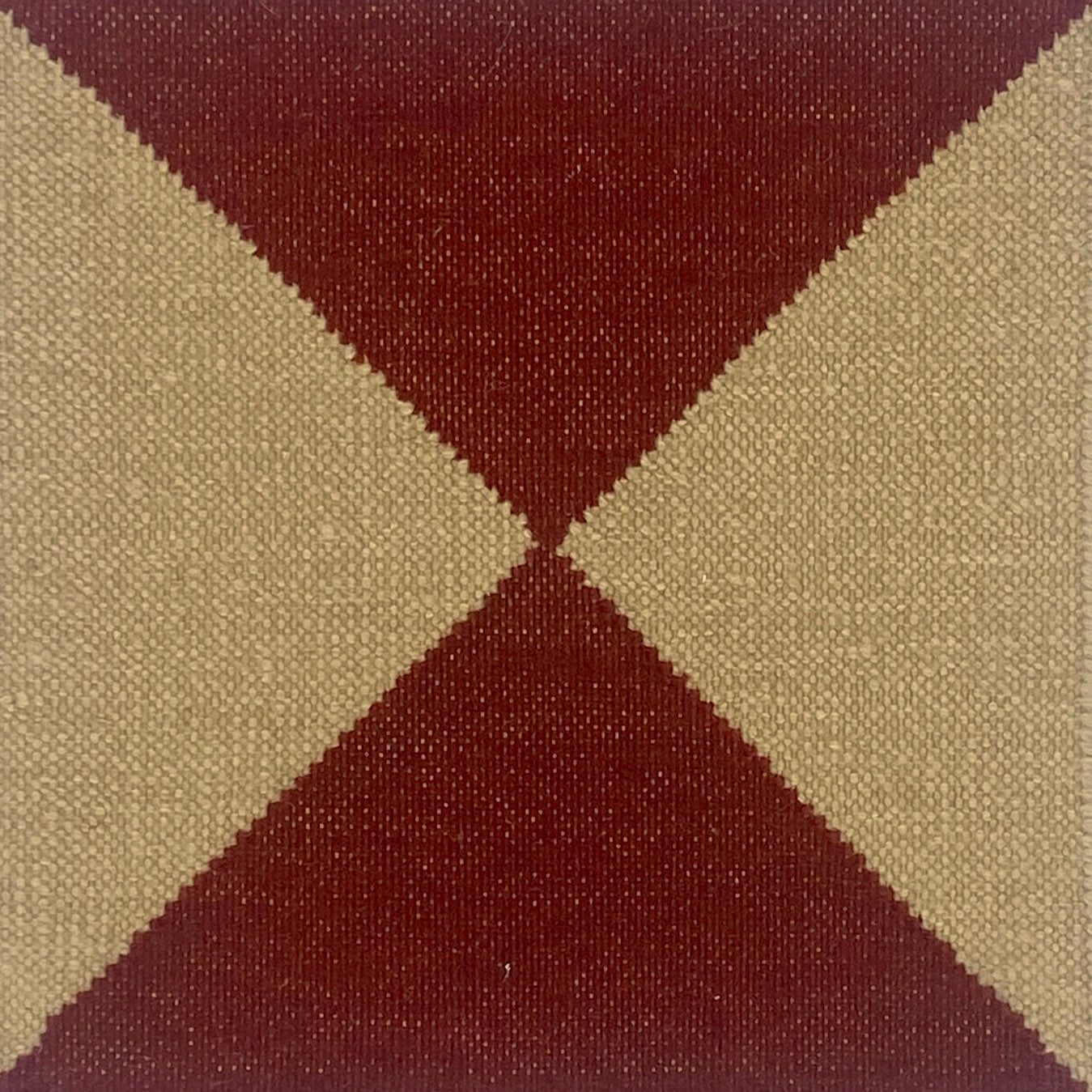 Close-up of a flatweave rug with a diamond pattern in red and cream