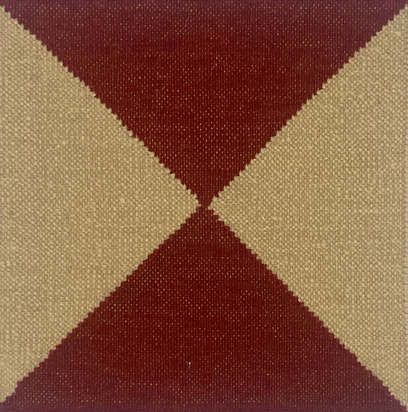 Close-up of a flatweave rug with a diamond pattern in red and cream