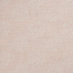 Detail of a printed linen fabric in a repeating camellia pattern in white on a light pink field.