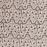 Detail of fabric in an abstract tribal print in black on a tan field.