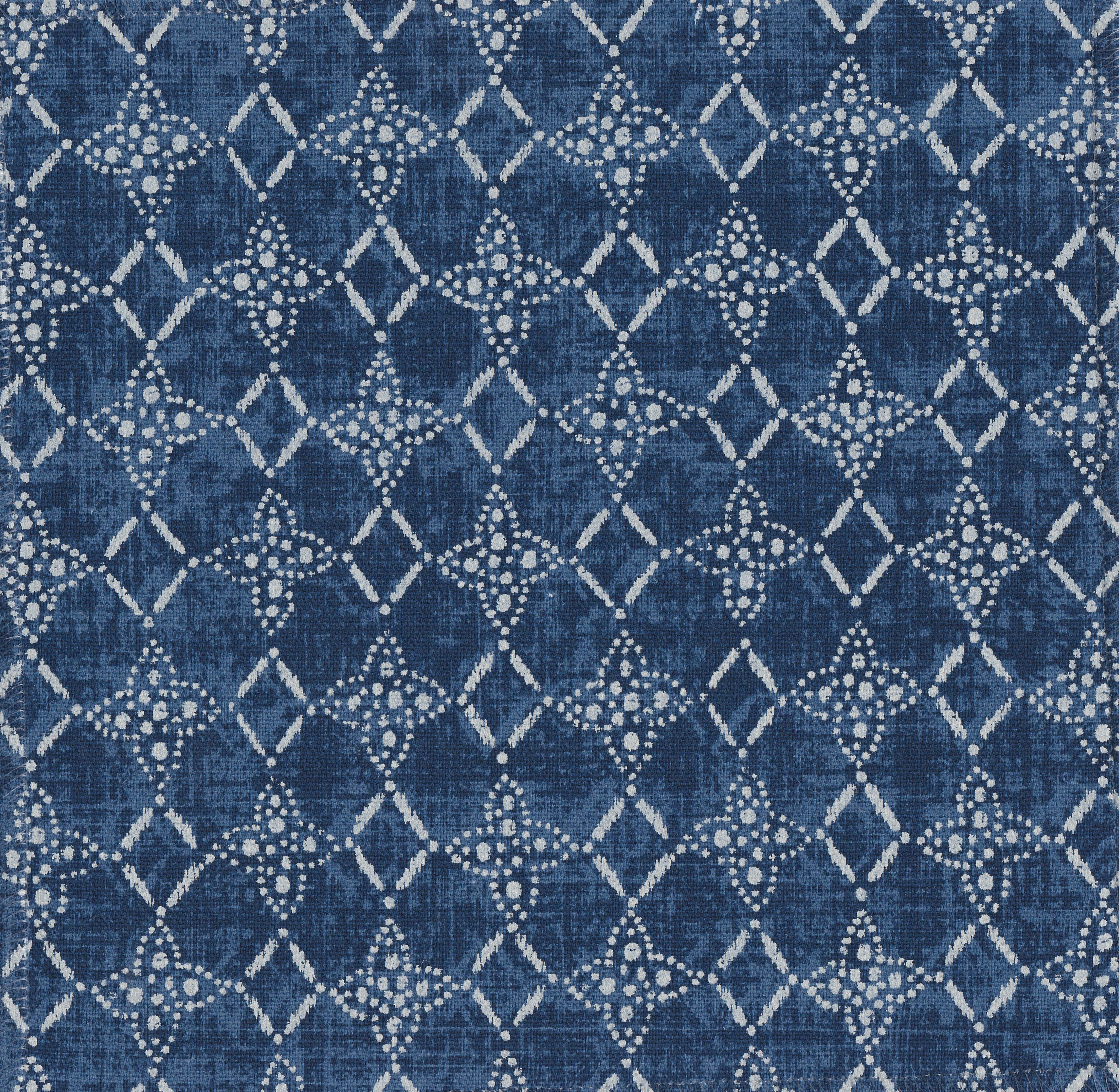 Detail of fabric in a botanical lattice print in gray on a mottled navy field.