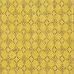 Detail of fabric in a botanical lattice print in brown on a mottled yellow field.