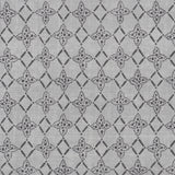 Detail of fabric in a botanical lattice print in charcoal on a mottled gray field.