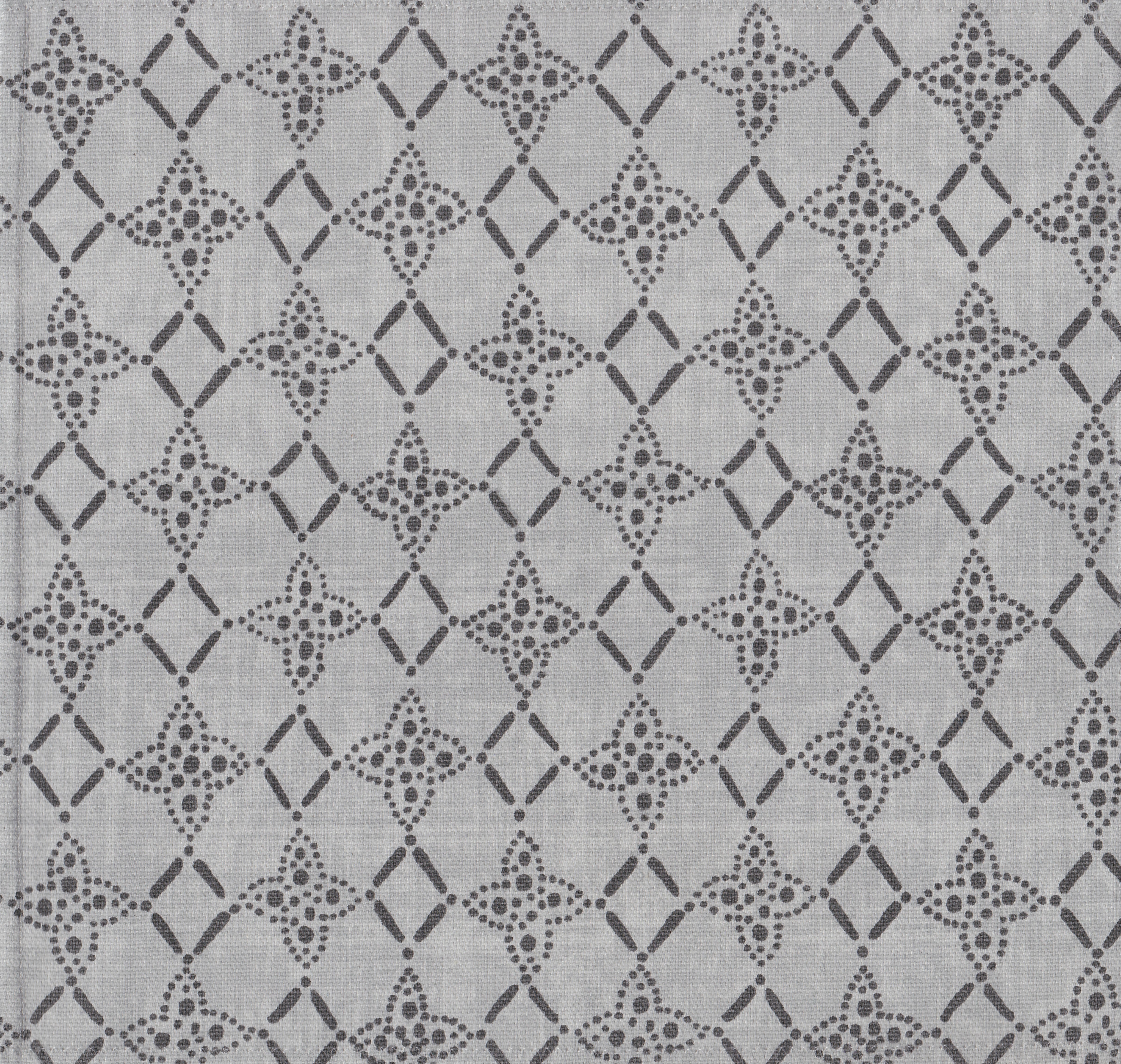 Detail of fabric in a botanical lattice print in charcoal on a mottled gray field.