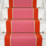 Striped flatweave runner in pink and red on white stairs