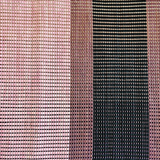 Close-up of a woven leather rug in an irregular stripe print in shades of pink, purple and black.