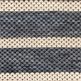 Close-up of a woven leather rug in an irregular stripe print in cream and navy.