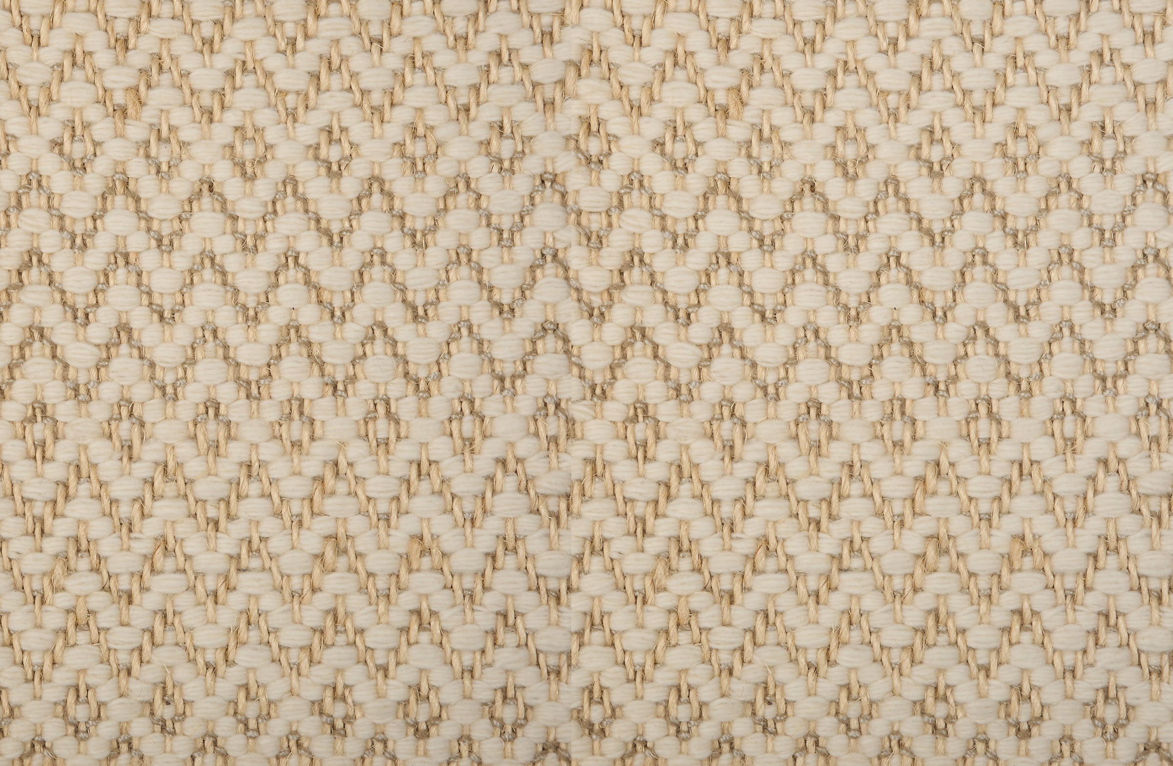 Broadloom carpet in a zig zag diamond pattern in cream and natural fibre. 