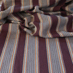 Draped Close-up of striped fabric with mixed color stripes. 