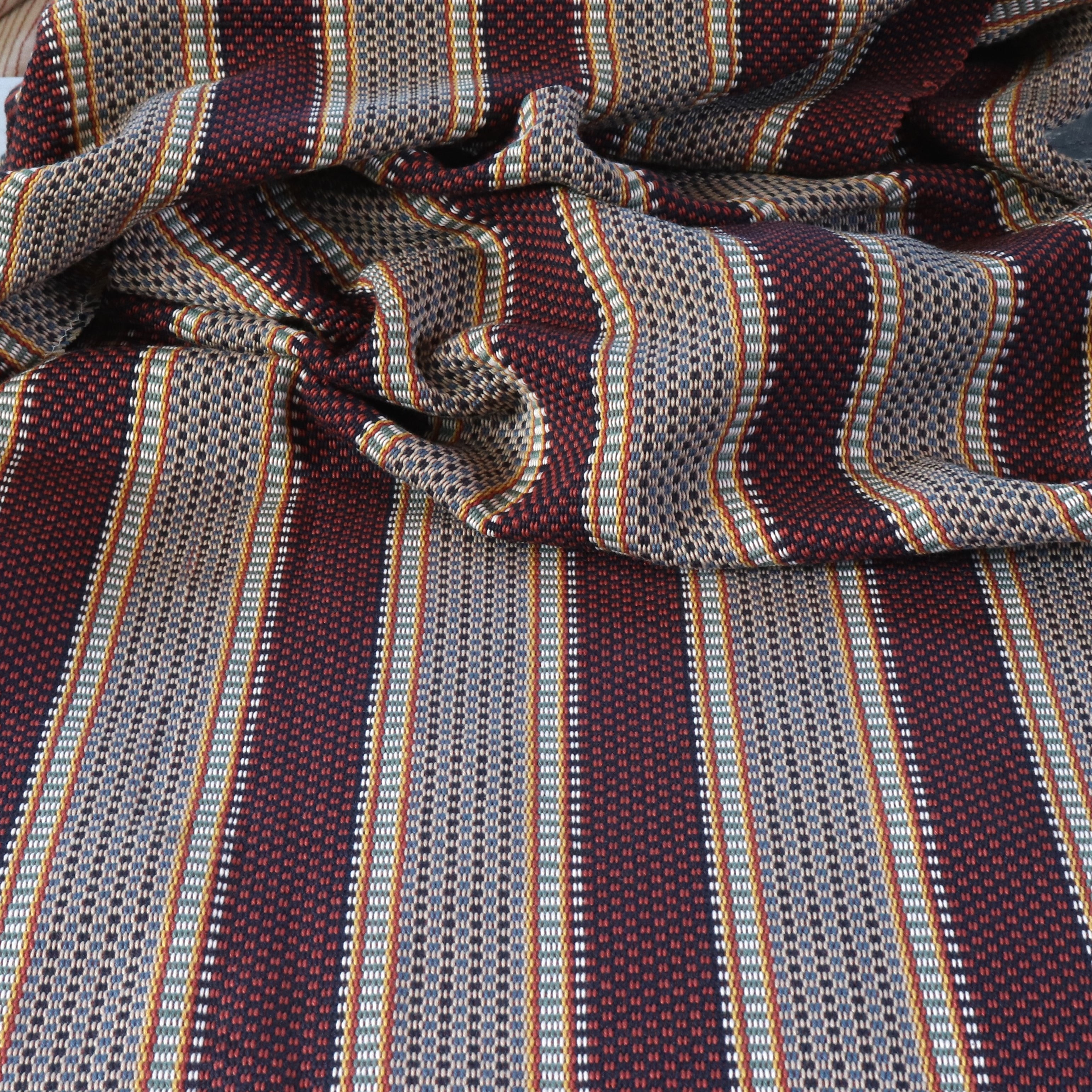Draped Close-up of striped fabric with mixed color stripes. 
