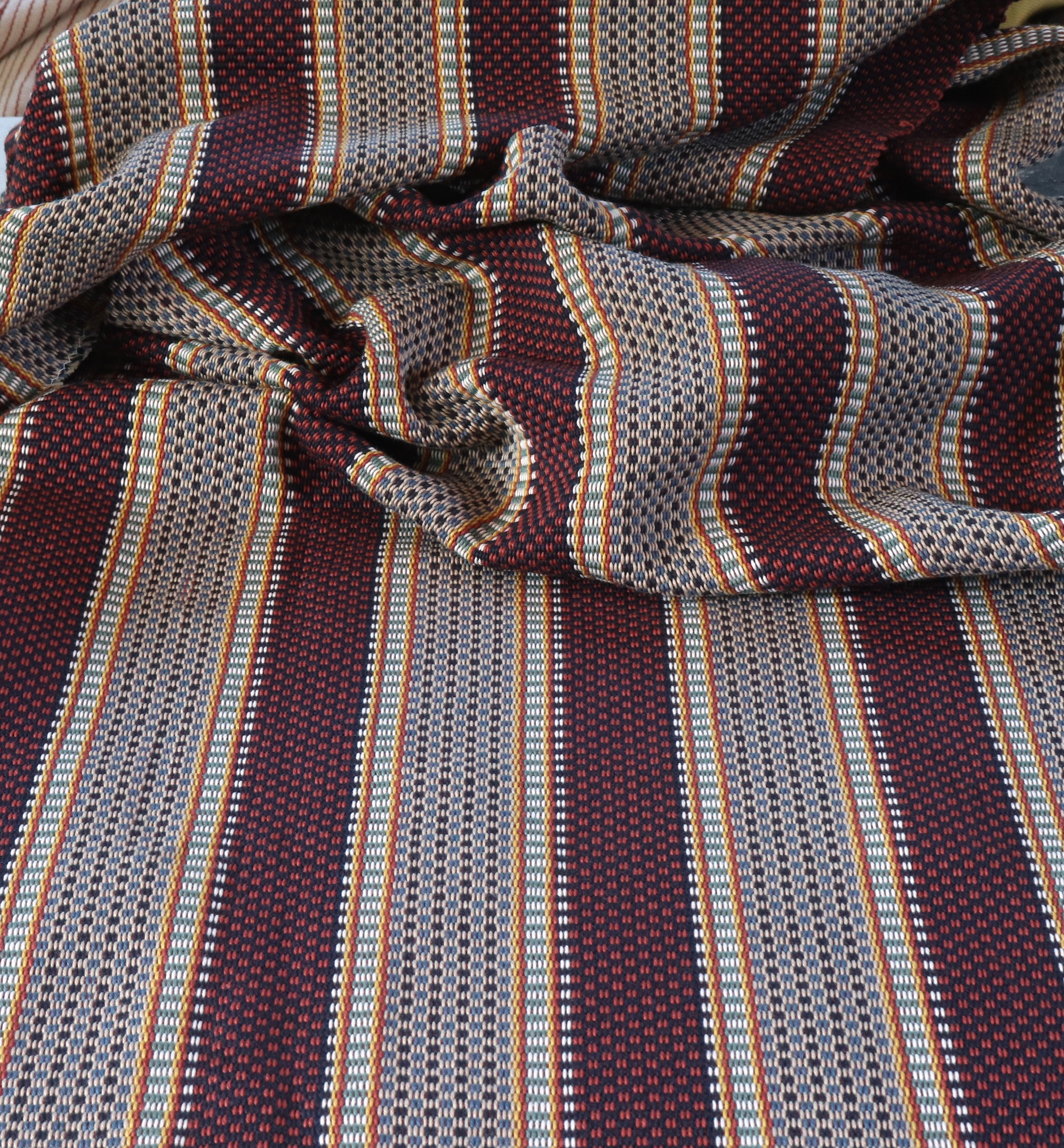 Draped Close-up of striped fabric with mixed color stripes. 