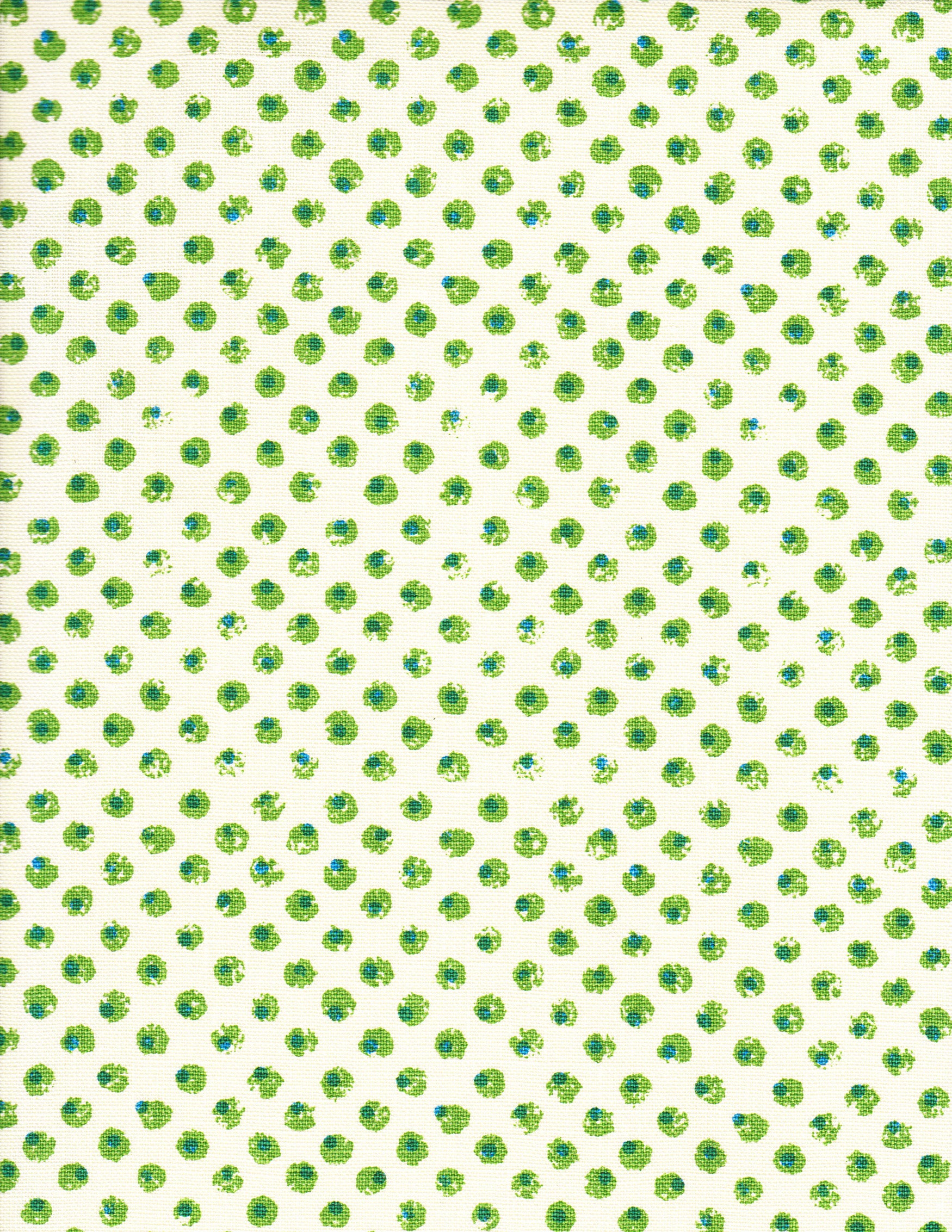 Detail of fabric in a painterly dot print in green and blue on a light yellow field.