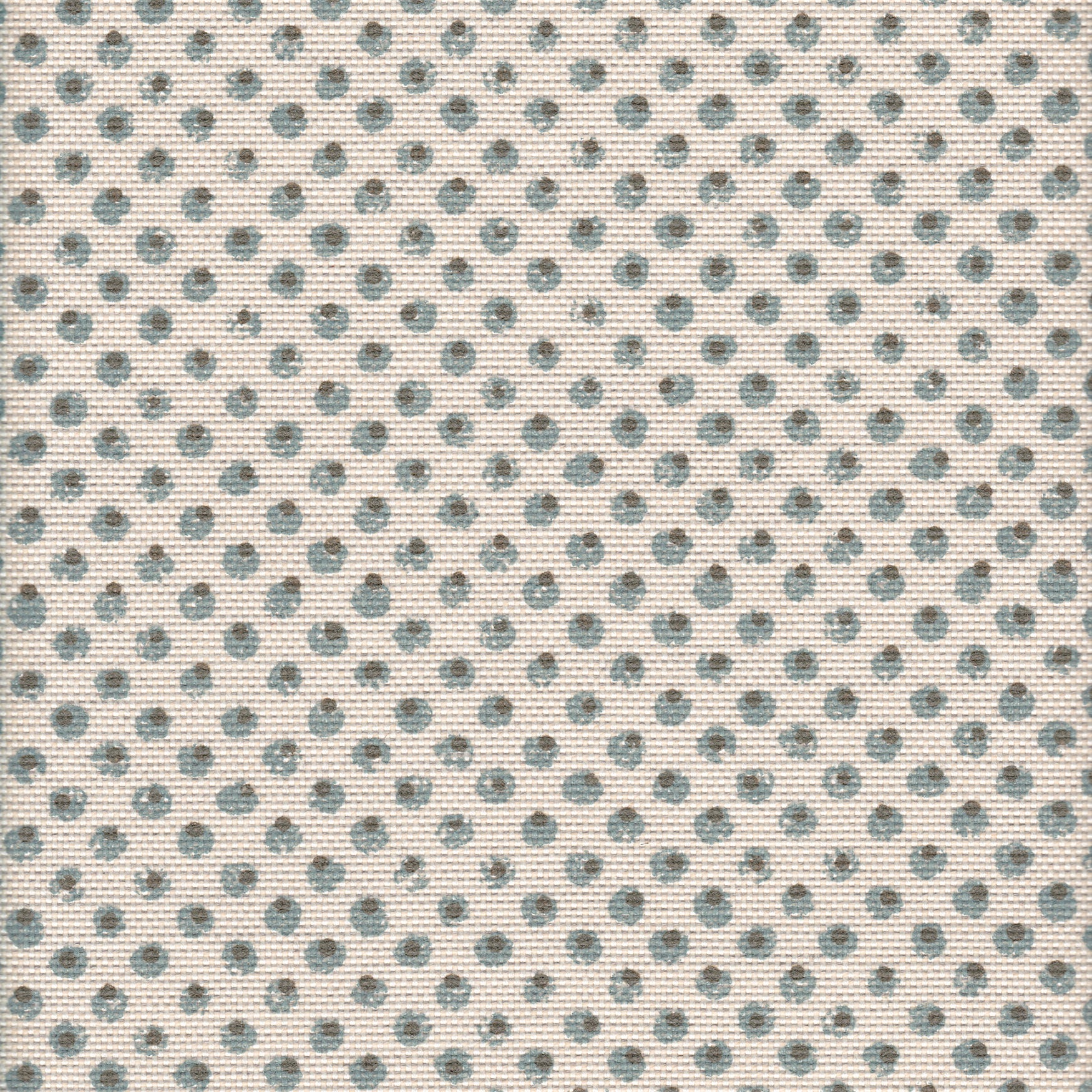 Detail of fabric in a painterly dot print in blue and brown on a cream field.