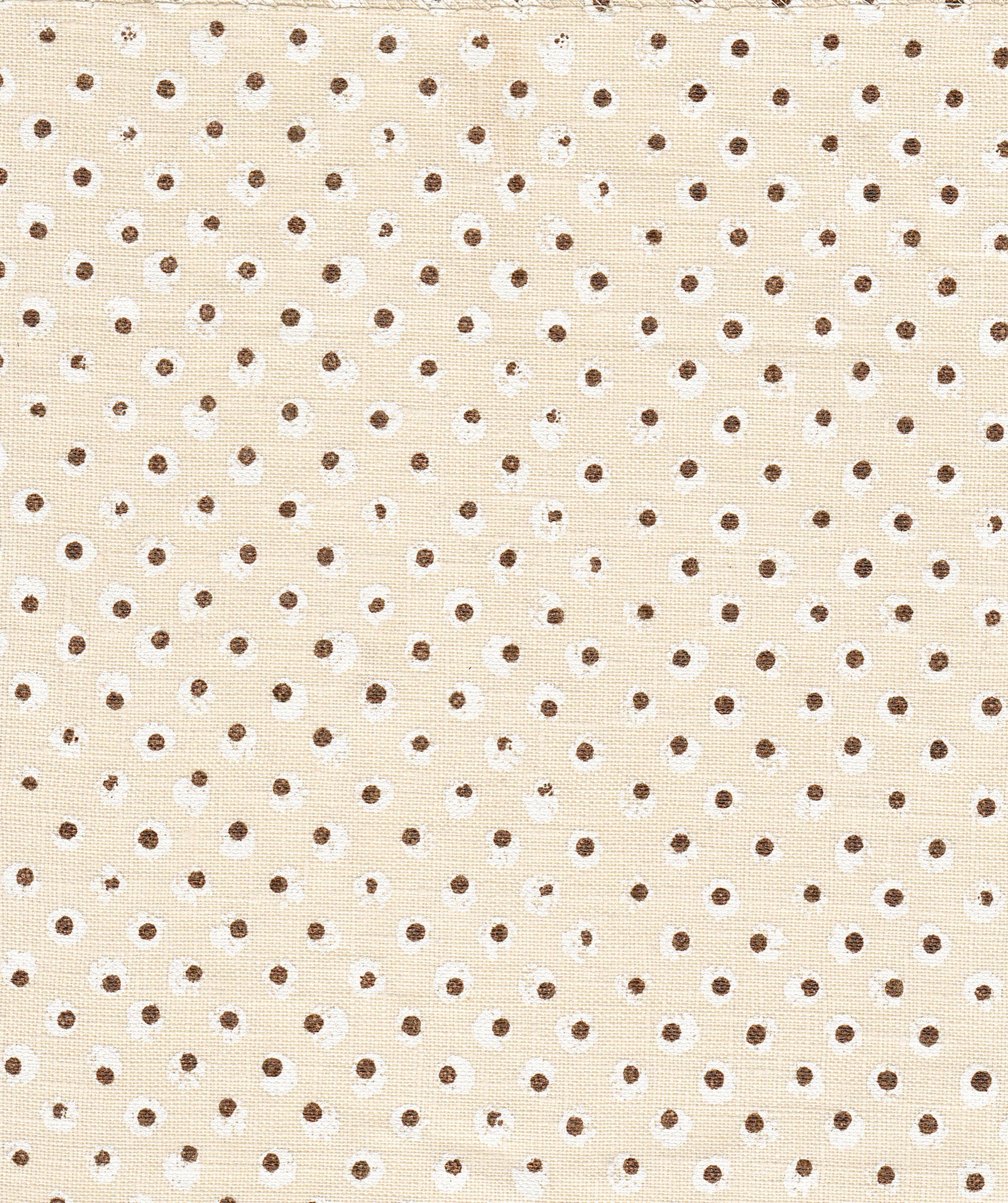 Detail of fabric in a painterly dot print in white and brown on a cream field.