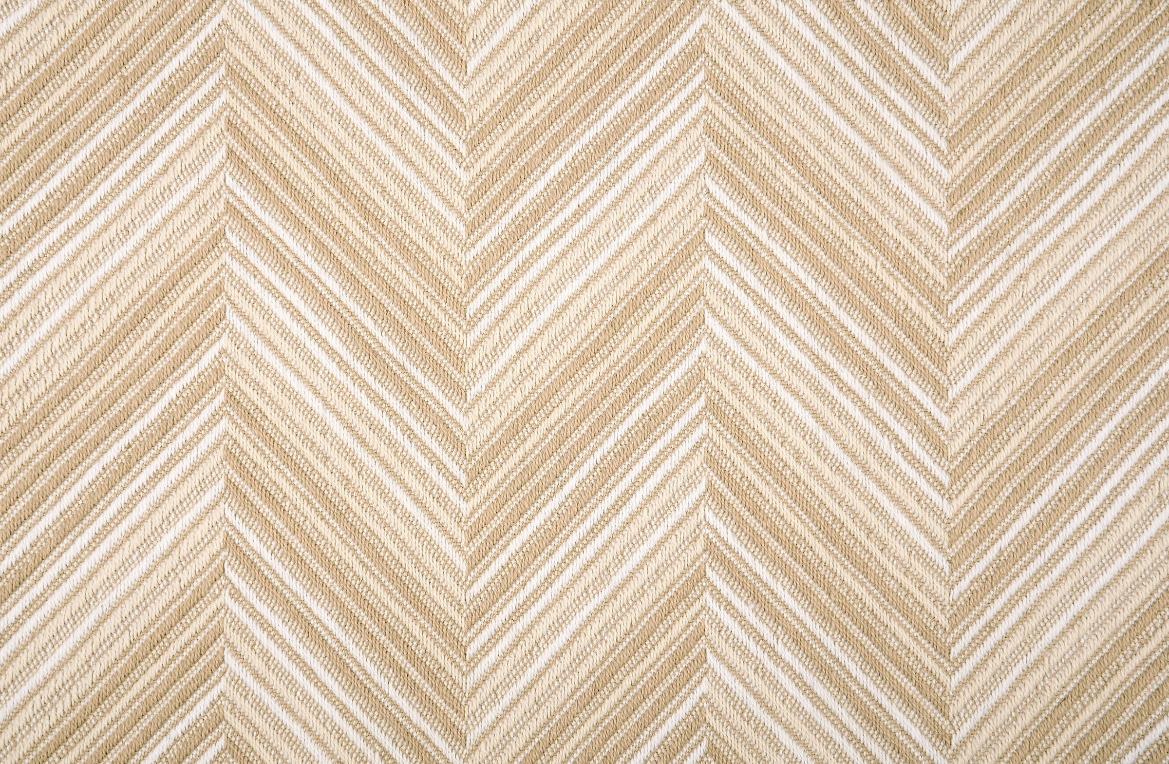 Broadloom carpet with a graphic herringbone pattern in shades of tan and white. 