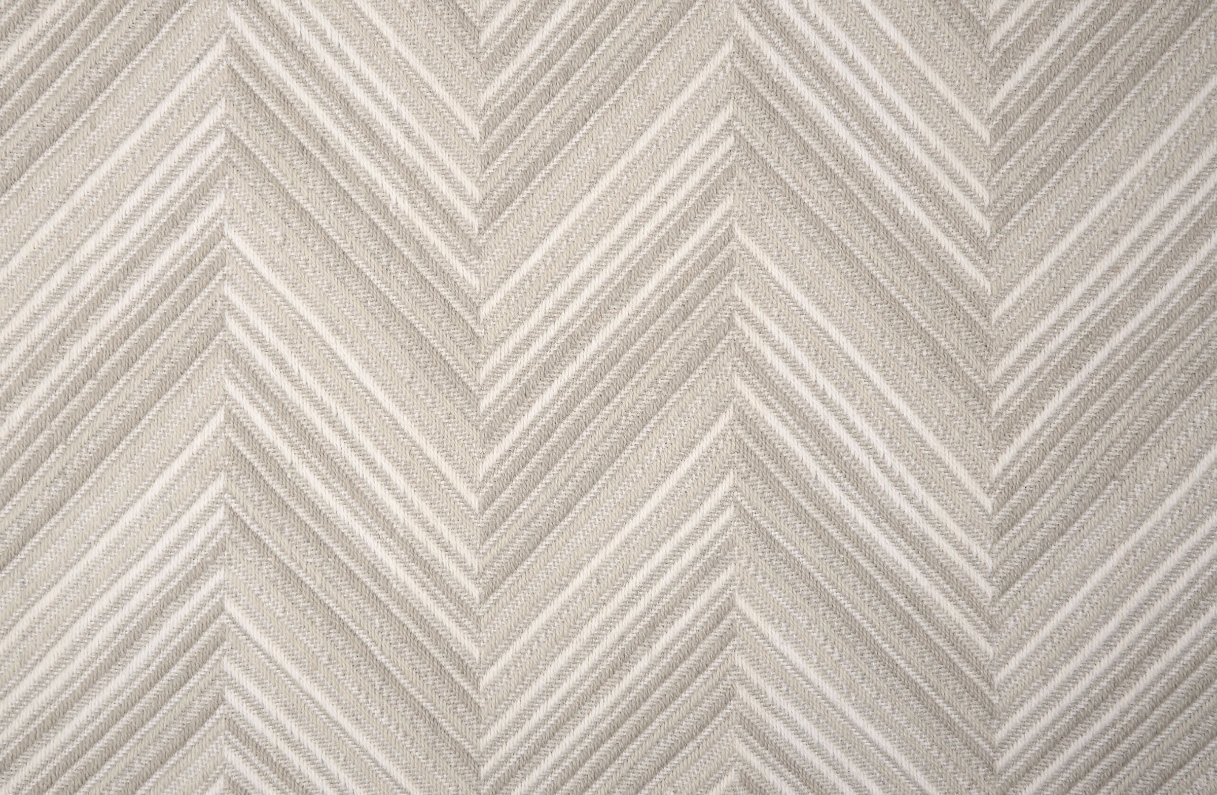 Broadloom carpet with a graphic herringbone pattern in shades of taupe. 