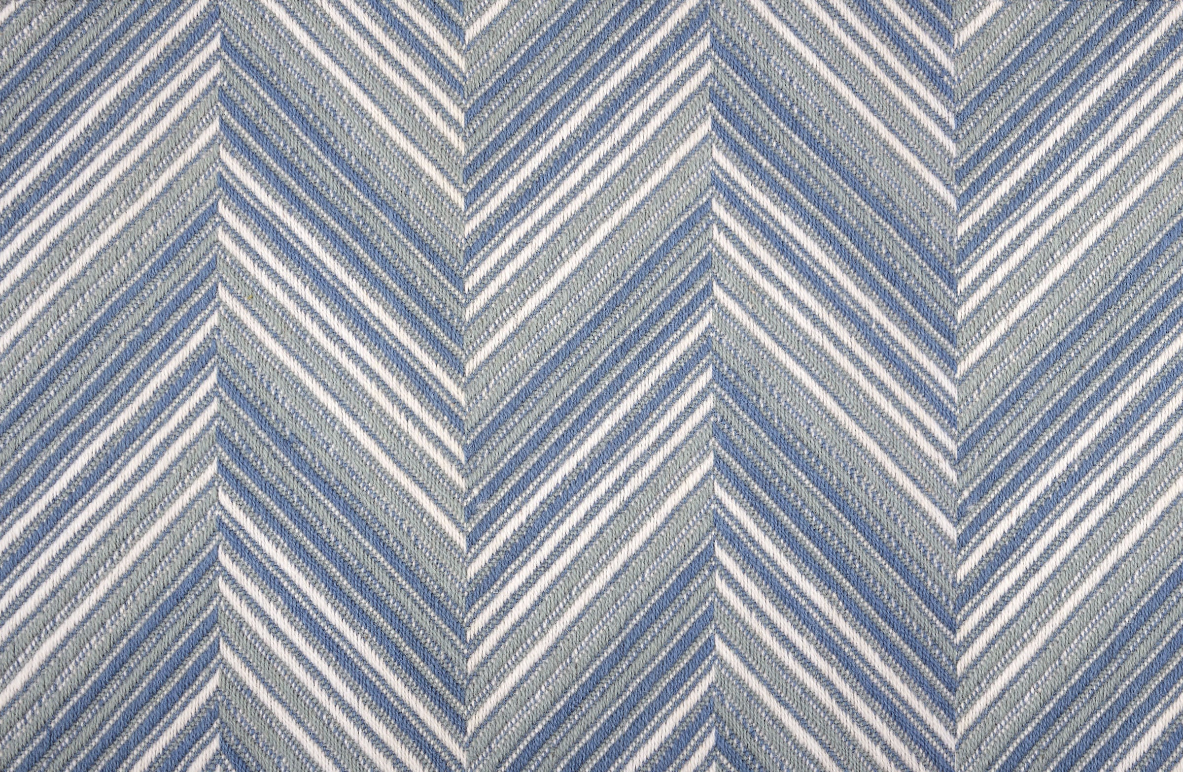 Broadloom carpet with a graphic herringbone pattern in shades of light blue and white. 