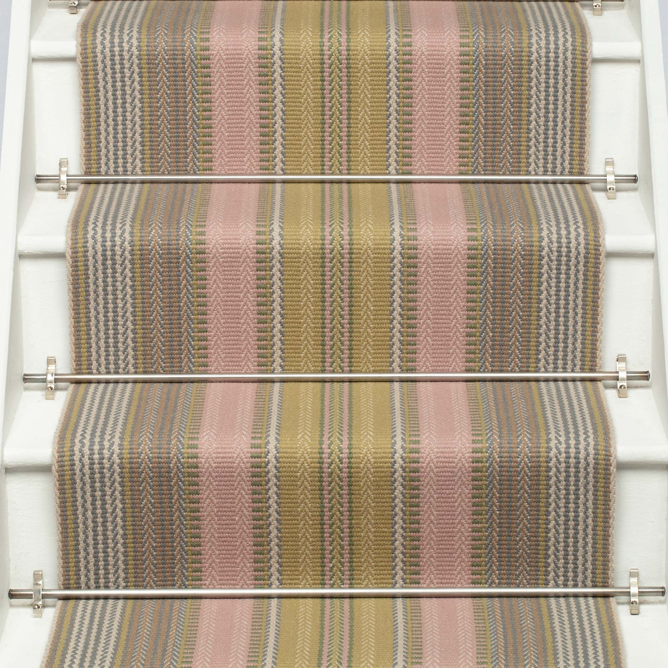 Striped flatweave runner in pink and sage on white staircase