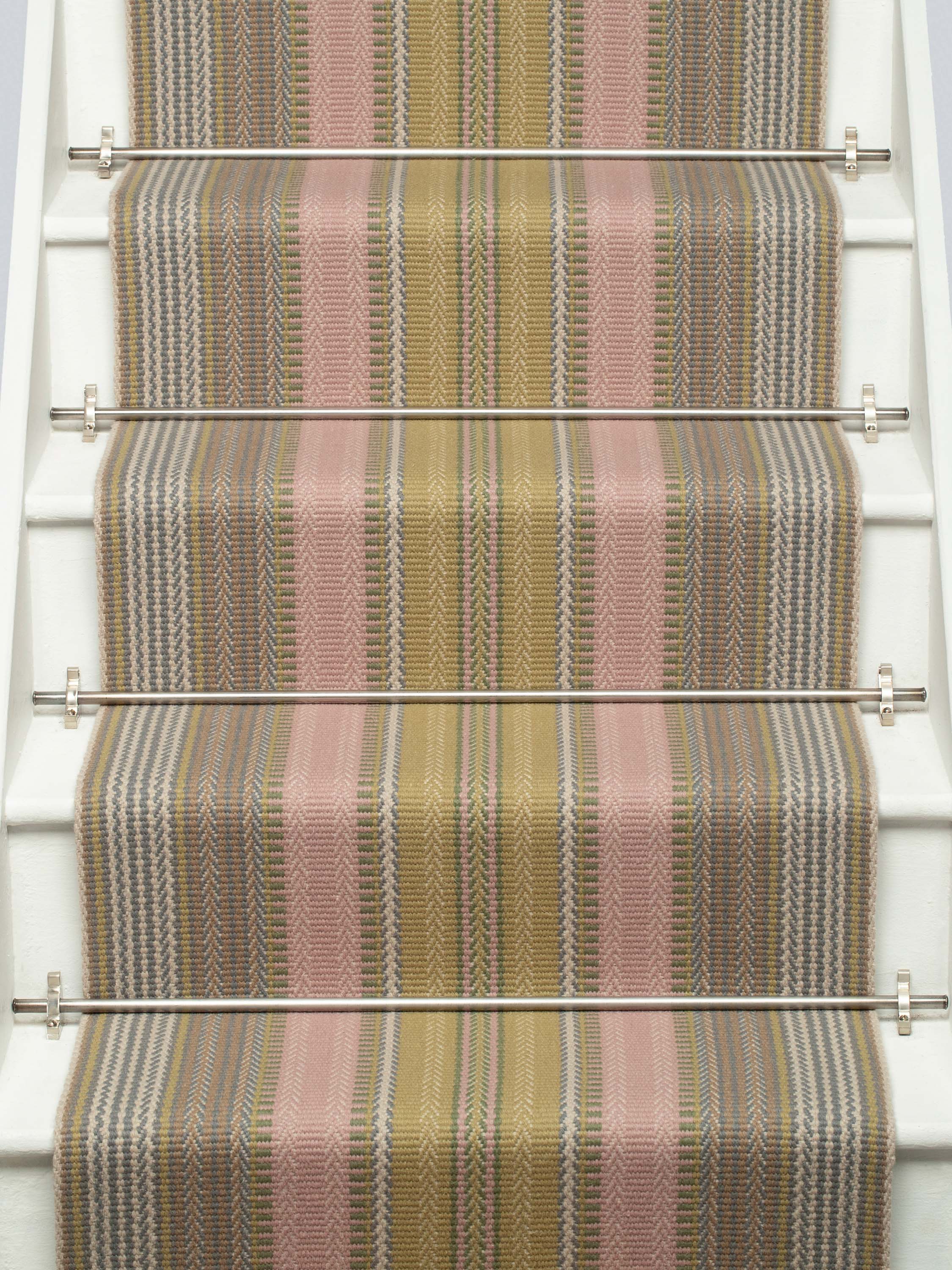 Striped flatweave runner in pink and sage on white staircase