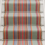 Striped flatweave runner in blue orange green and red on white staircase