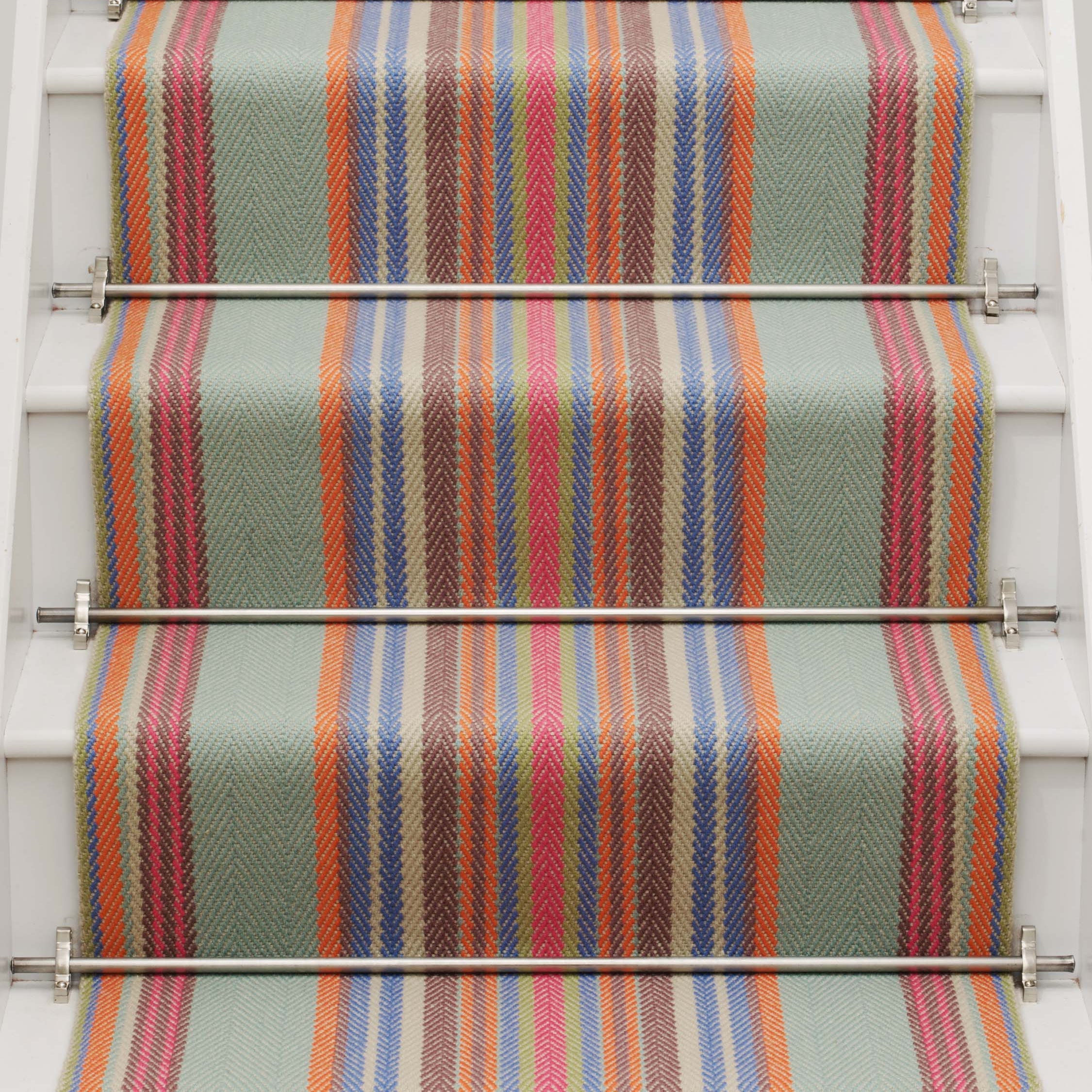 Striped flatweave runner in blue orange green and red on white staircase