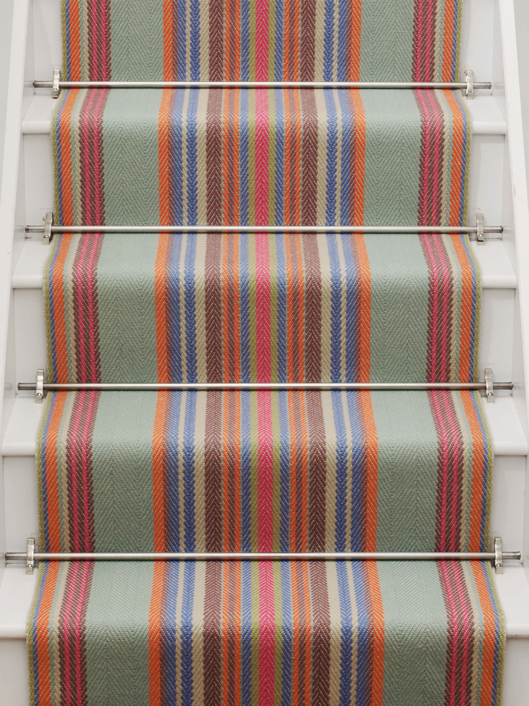 Striped flatweave runner in blue orange green and red on white staircase