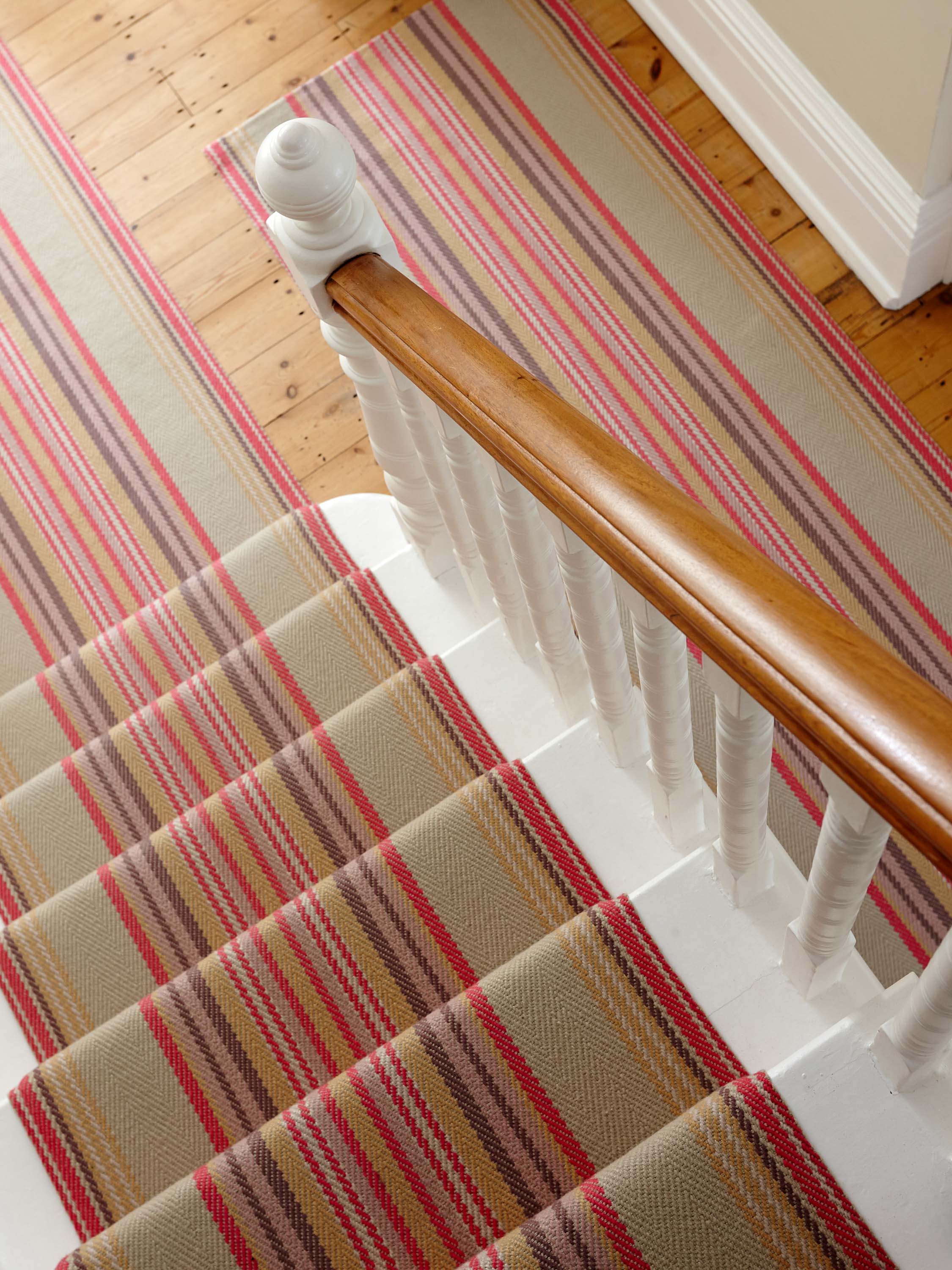 Striped flatweave runner in blue orange green and red on white staircase