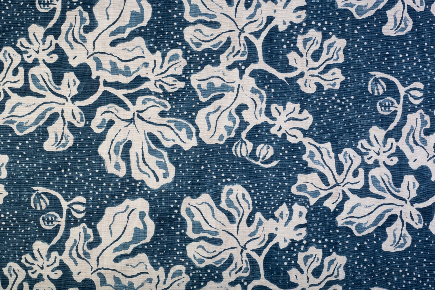 Detail of fabric in a playful botanical print in blue and white on a navy field.