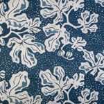 Detail of fabric in a playful botanical print in blue and white on a navy field.