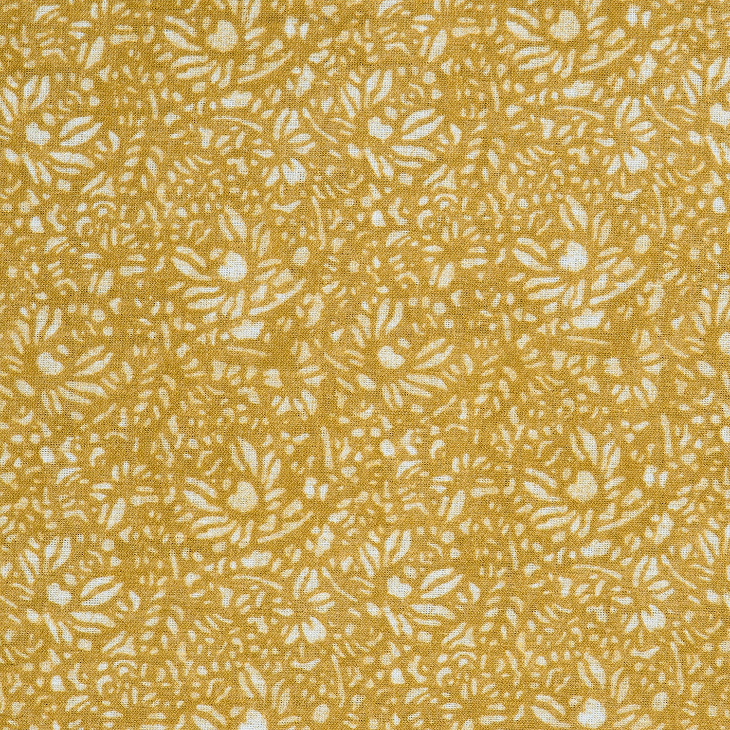Detail of a printed linen fabric in a repeating chrysanthemum pattern in white on a mustard field.
