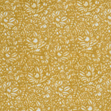 Detail of a printed linen fabric in a repeating chrysanthemum pattern in white on a mustard field.