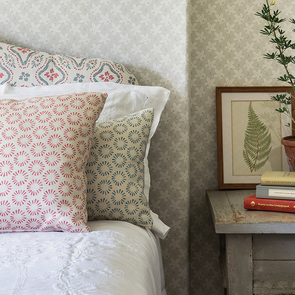 Close-up shot of a bed with an upholstered headboard and throw pillows in a playful circular print.